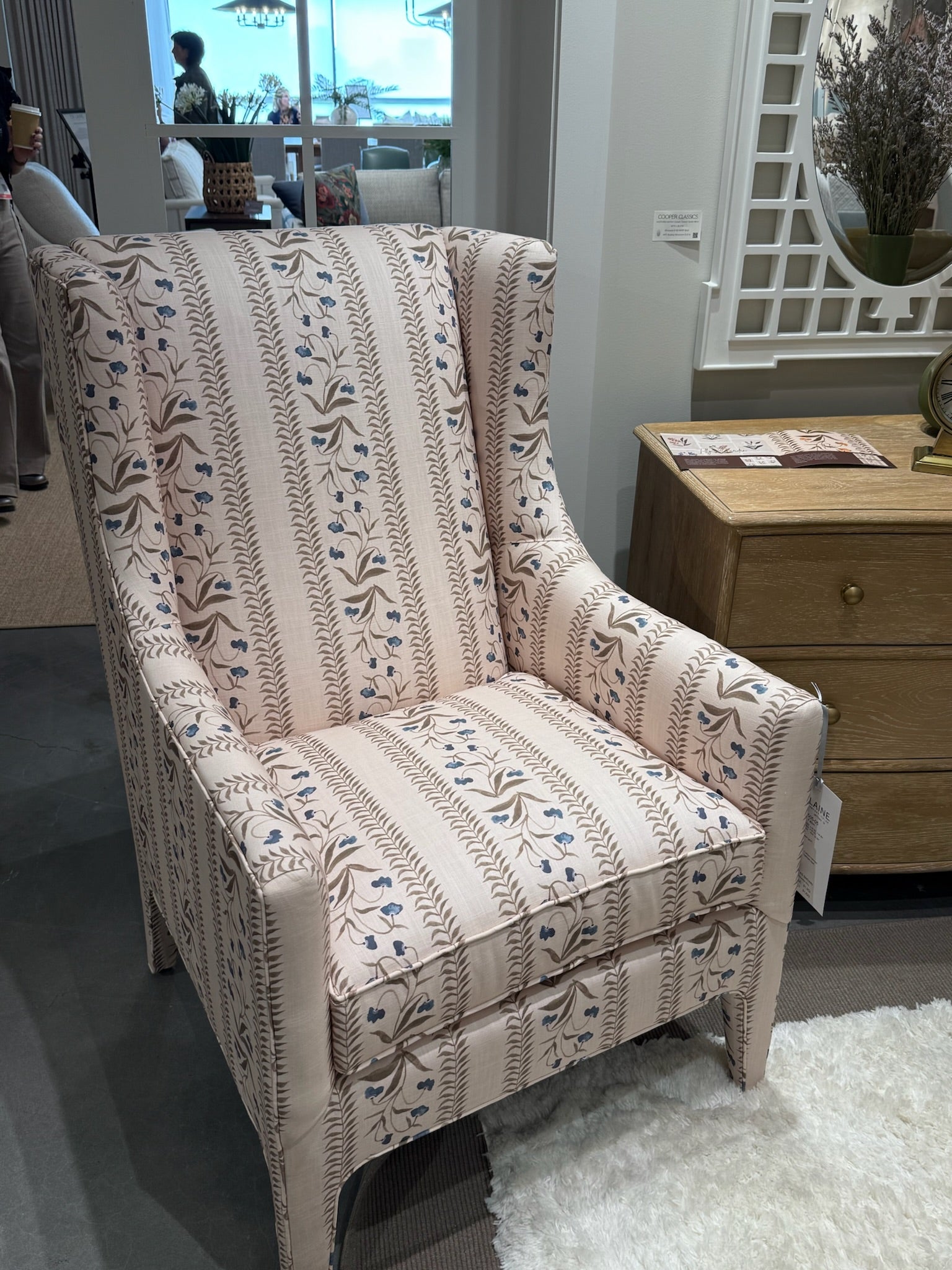 Wingback chair upholstered in EH x Renee Bouchon Tula fabric in Lapis, featuring pink linen with blue floral stripes.