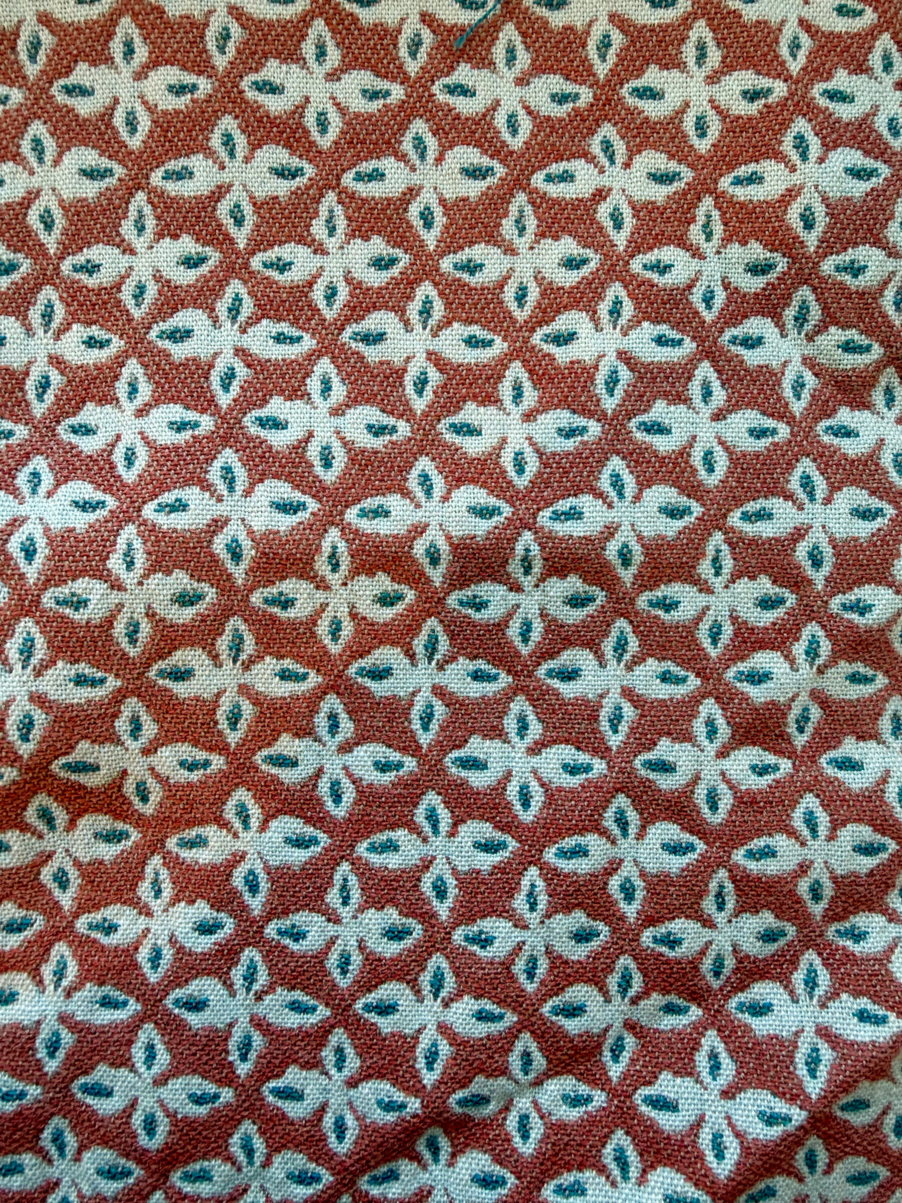 Cadet red EH x Sunbrella Posey fabric sample with repeating white and teal floral pattern.