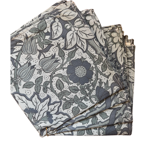 Set of four folded Flora Cobalt 18x18" cotton napkins with blue floral and leaf patterns.