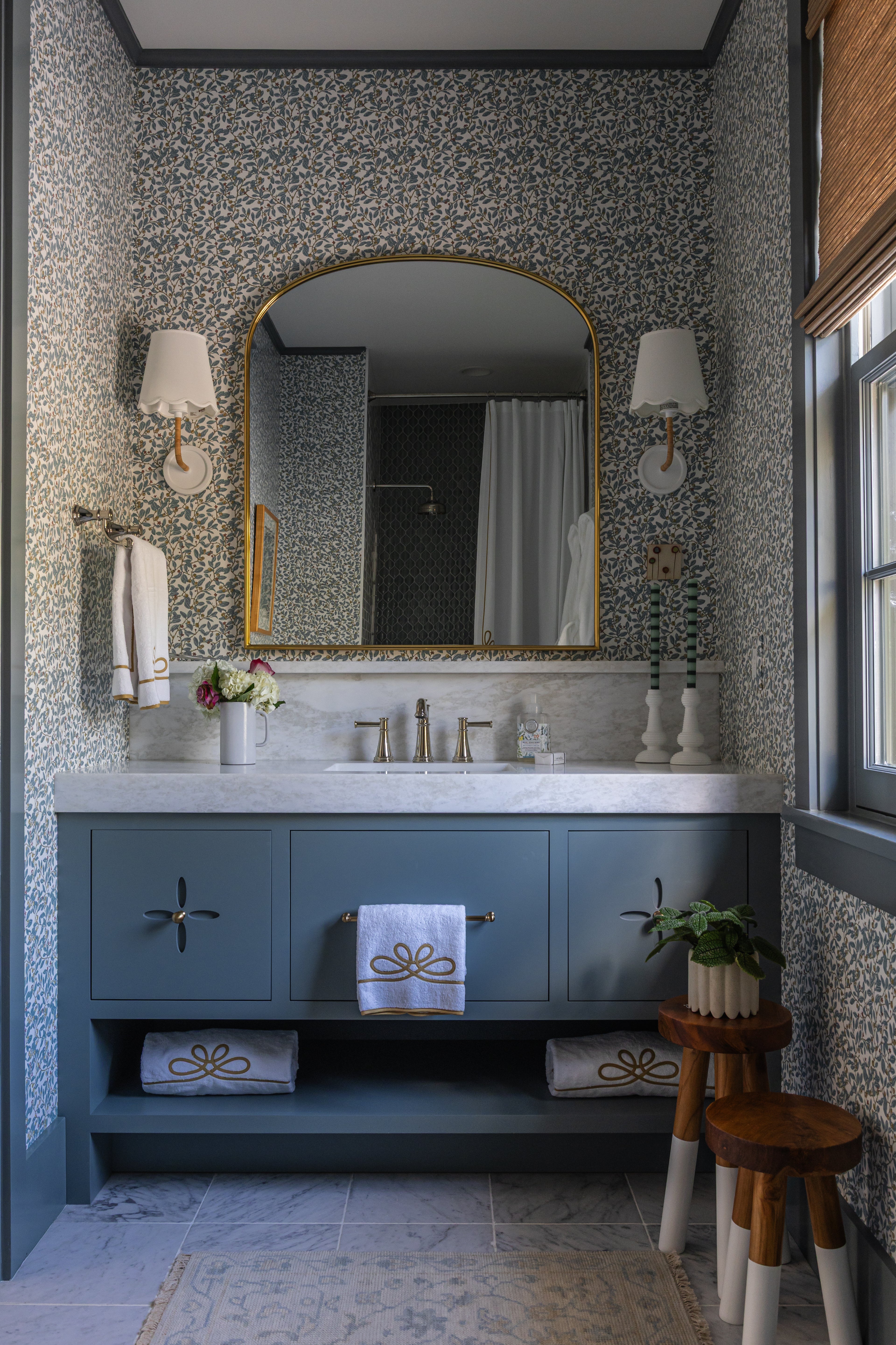 Blue Limes Wallpaper with a subtle floral pattern in a stylish bathroom featuring a vanity and gold mirror.