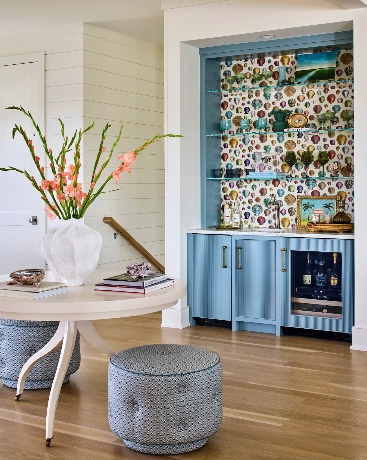 Marine Della Dot fabric on two round ottomans in a coastal-style room with a blue bar.