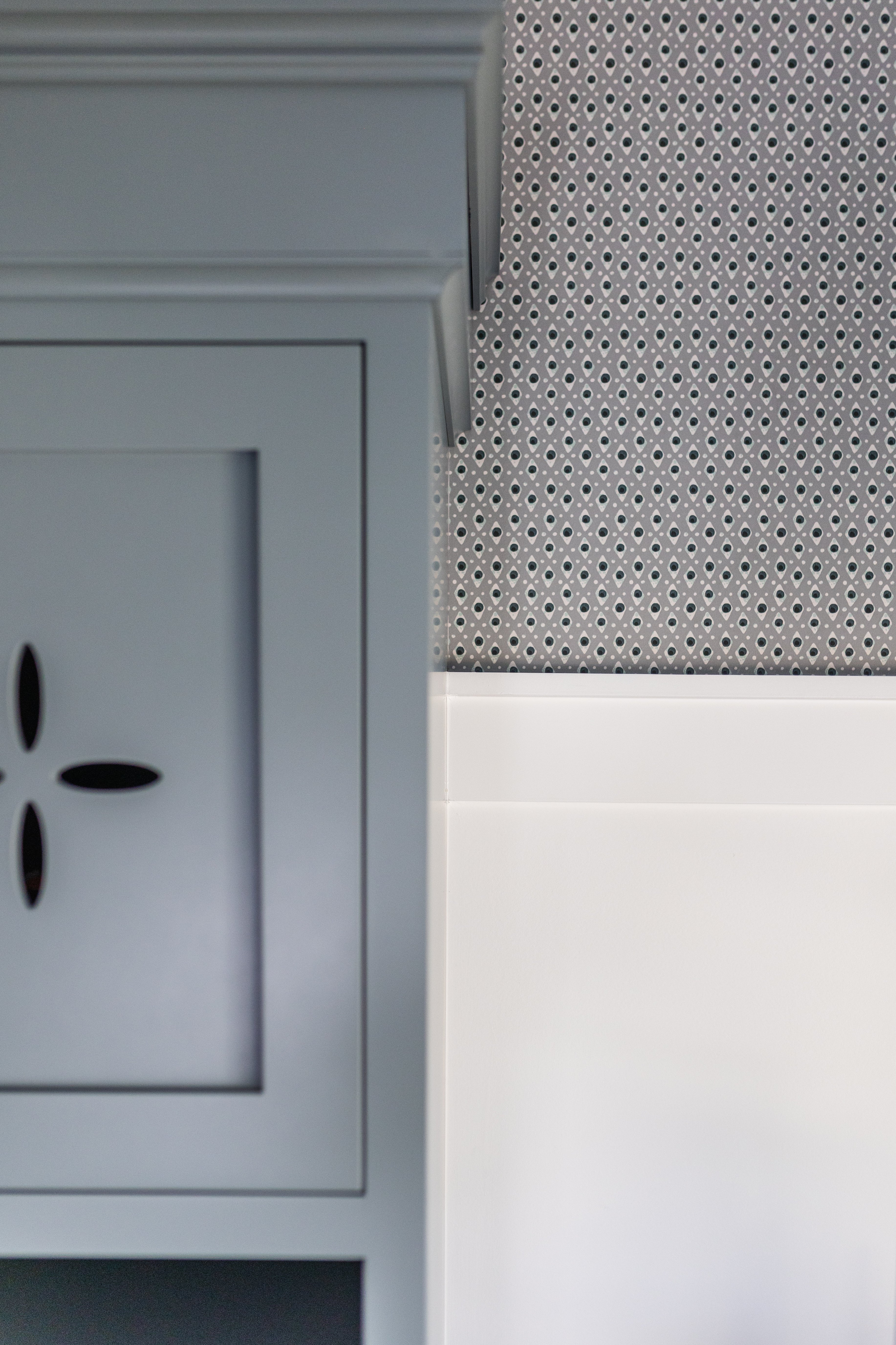 Della Dot Marine clay coated wallpaper with small repeating geometric pattern next to a light gray cabinet.