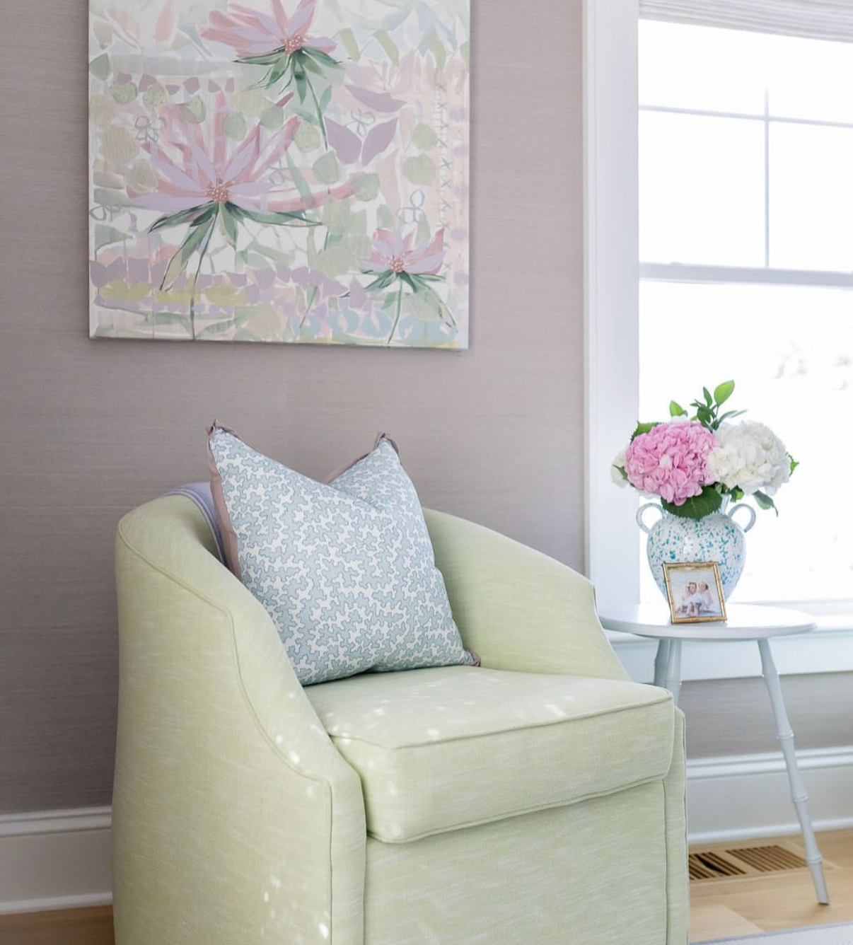 Dover Fabric - Pool: light green linen-cotton blend chair with a blue patterned pillow and floral artwork.