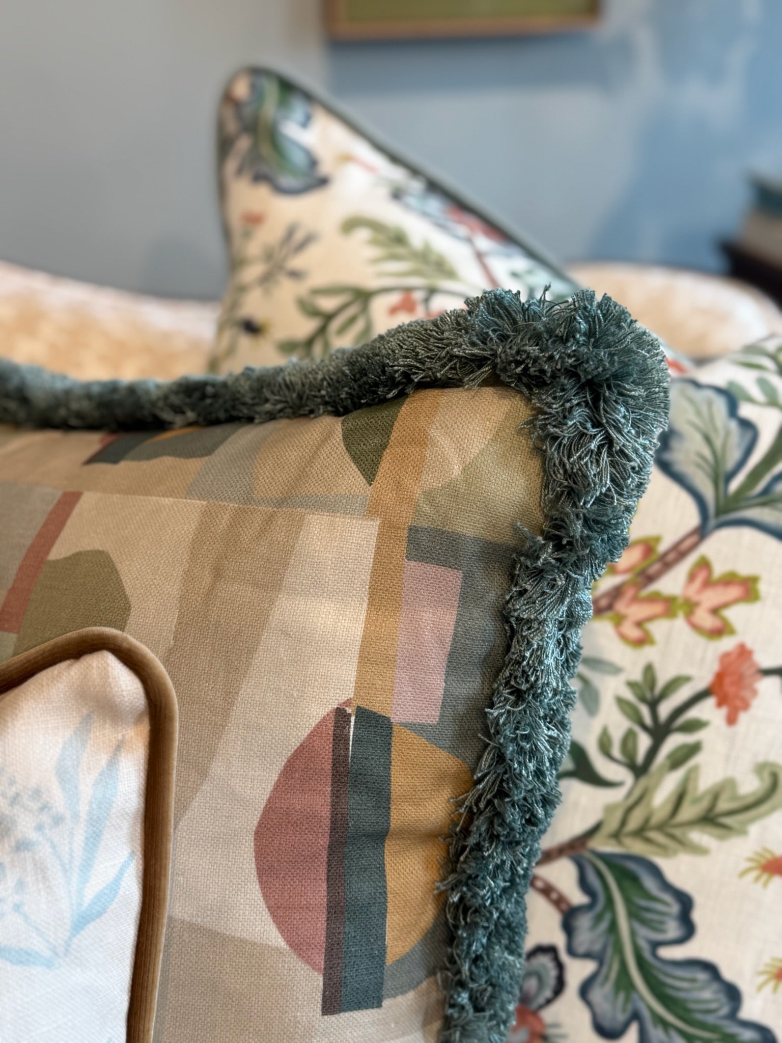 EH x Renee Bouchon Kipsy Multi linen pillow with abstract shapes and teal fringe trim.