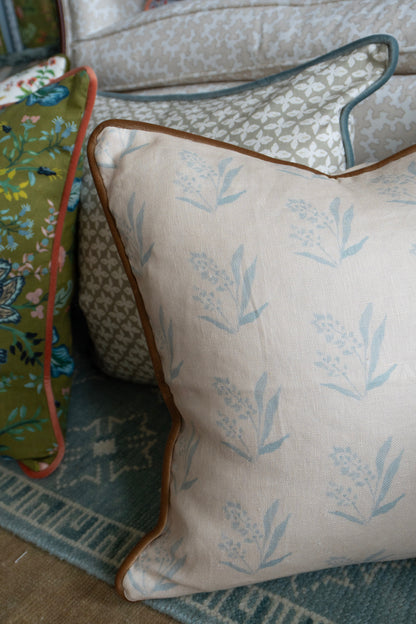 Linen pillow in EH x Renee Bouchon Marbella Sea fabric, light blue botanical pattern on cream with brown piping.