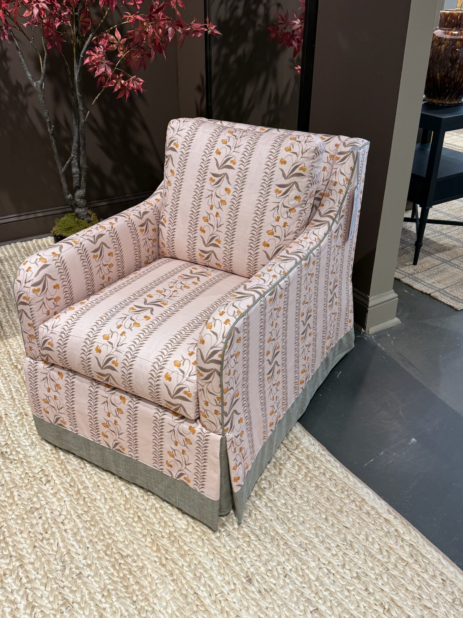 EH x Renee Bouchon Tula Fabric Yardage in Daffodil, a pink linen armchair with floral and striped patterns.
