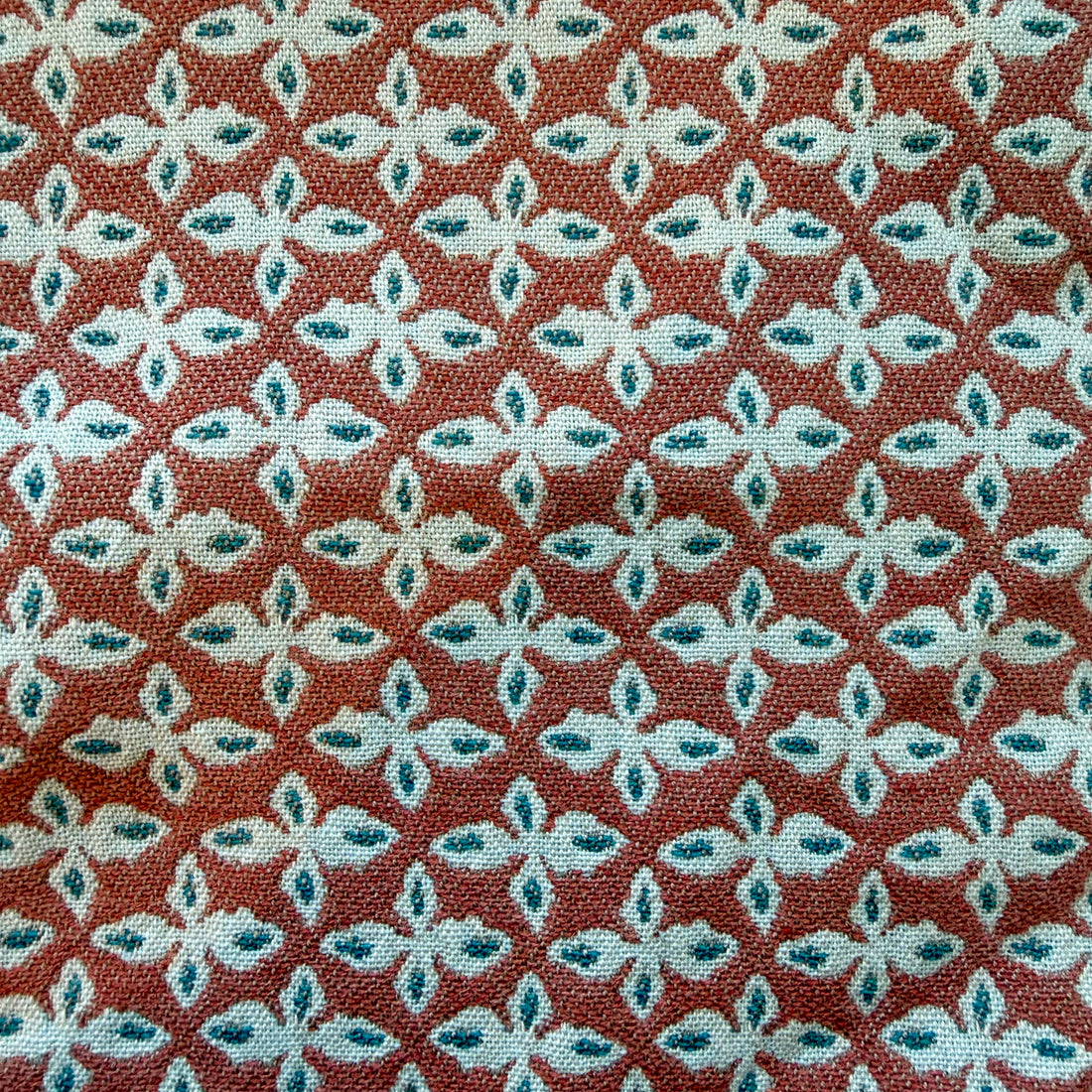 Cadet red EH x Sunbrella Posey fabric sample with repeating white and teal floral pattern.