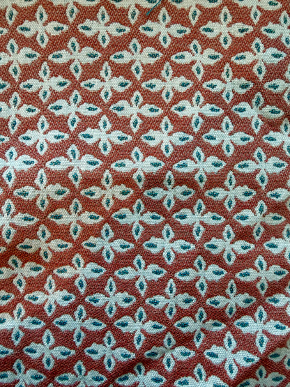 Cadet red EH x Sunbrella Posey fabric sample with repeating white and teal floral pattern.