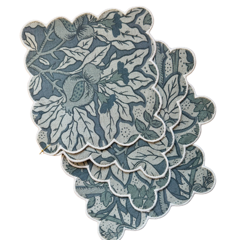 Set of four Flora Cobalt scalloped linen cocktail napkins with botanical print and pink trim.