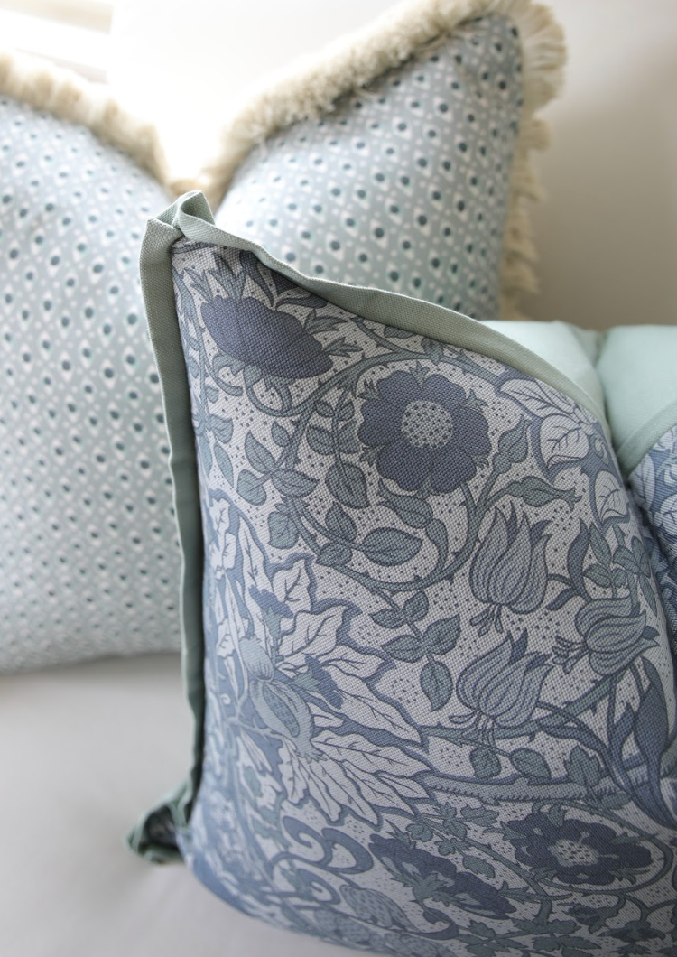 Cobalt Flora Fabric on a Belgian Oyster Linen pillow with green piping, featuring a detailed floral pattern.