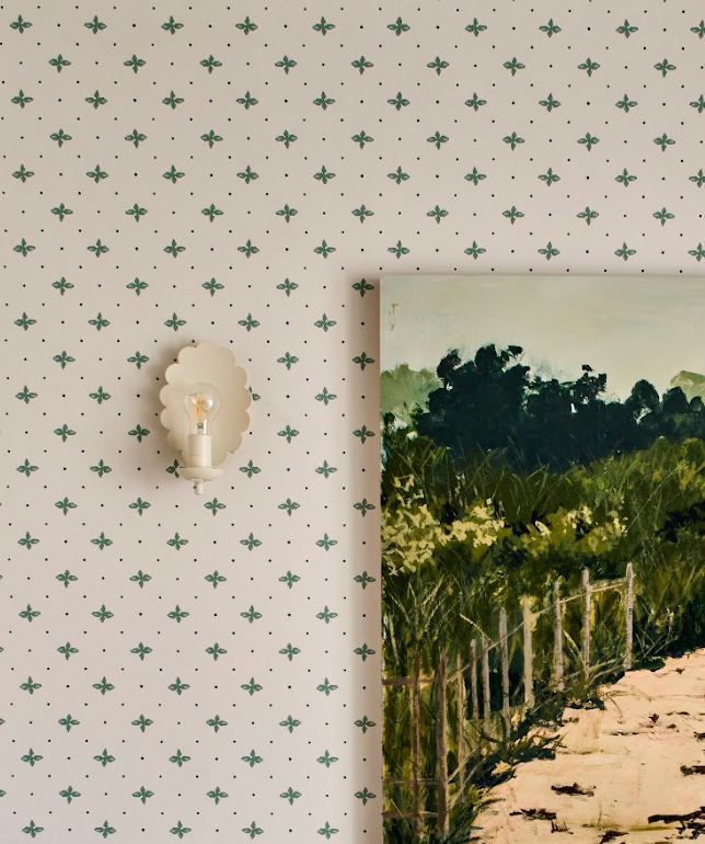 Folly Fern clay coated wallpaper with green floral pattern, white scalloped sconce, and nature painting.