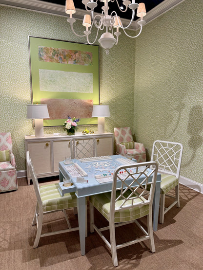 Dover Apple clay coated wallpaper with a subtle green pattern in a room with a game table and chairs.