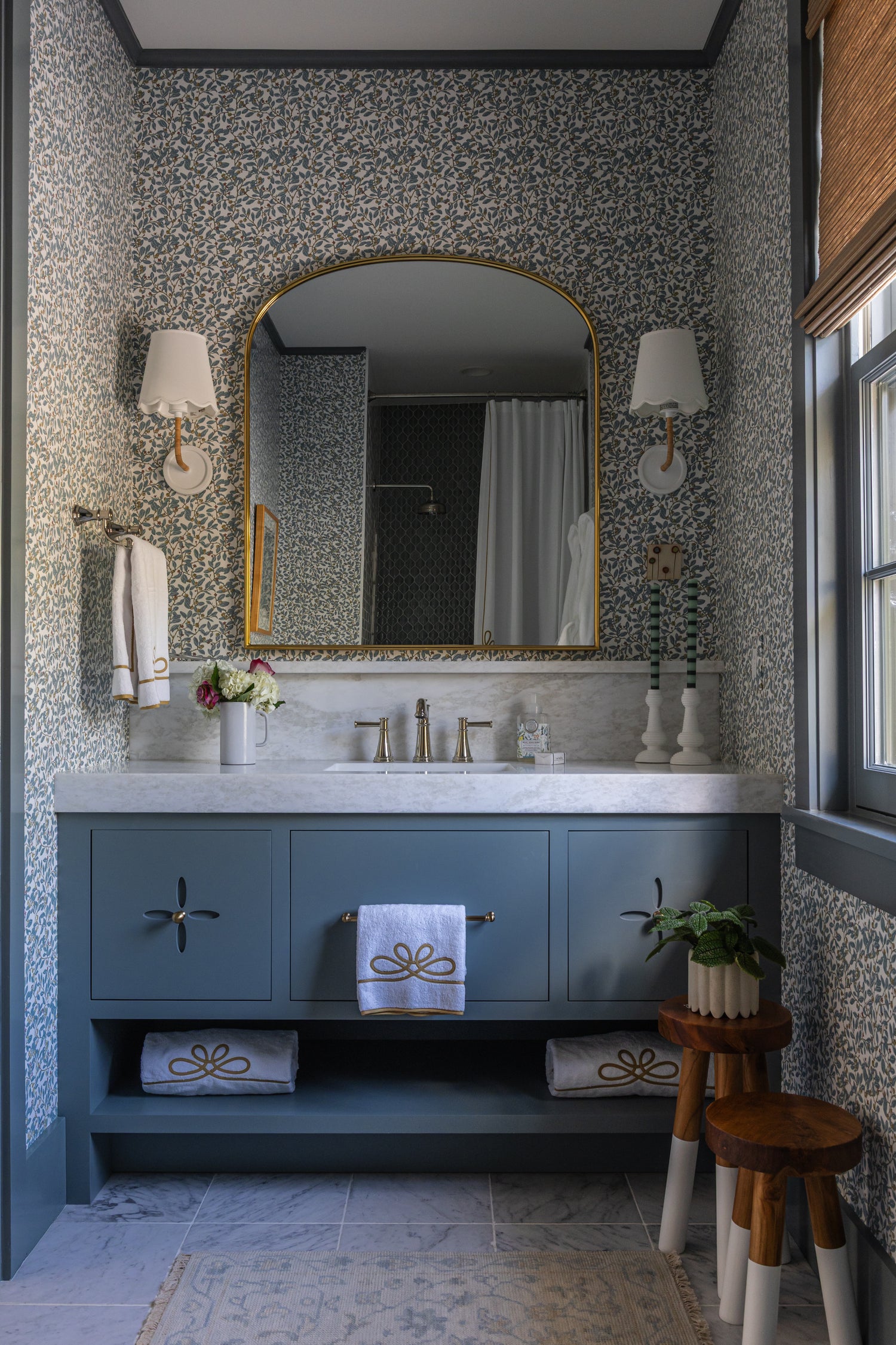 Blue Limes Wallpaper with a subtle floral pattern in a stylish bathroom featuring a vanity and gold mirror.