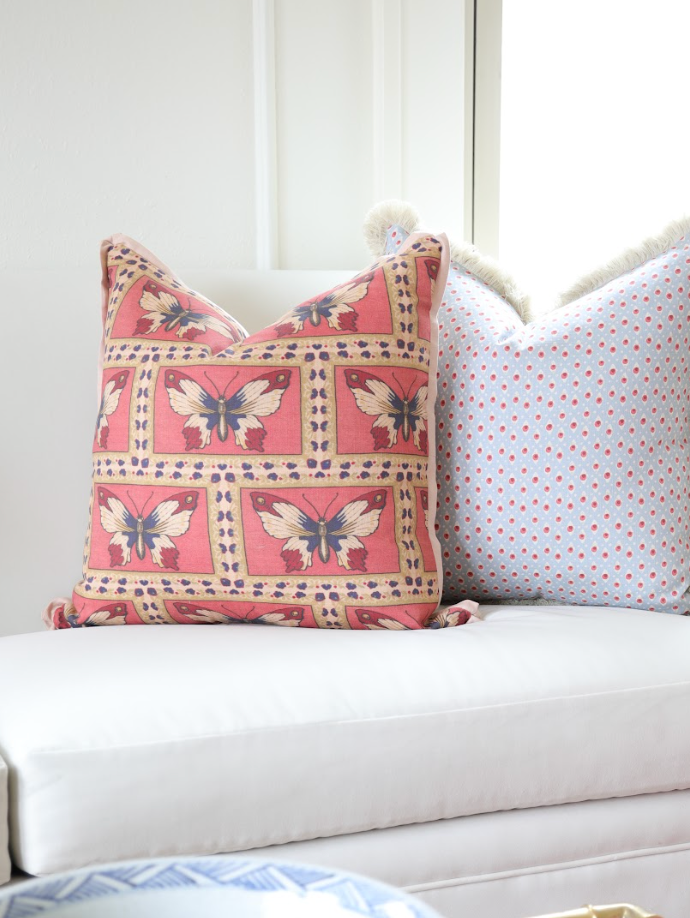 Monarch Fabric Rouge linen-cotton blend pillow with butterfly pattern; light blue polka dot pillow behind it.