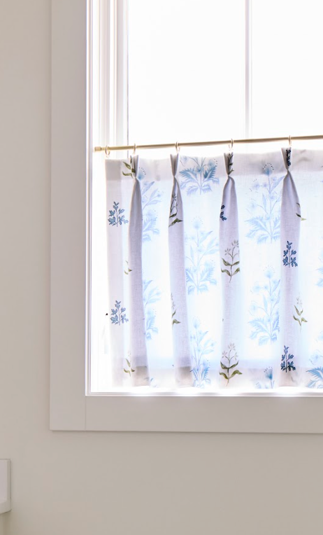 Perennial Sprout Belgian Linen fabric sample, light blue floral pattern on white cafe curtain.