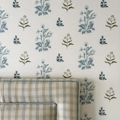 Perennial Grasscloth - Sprout wallpaper with blue floral sprigs on a white background, above a plaid headboard.