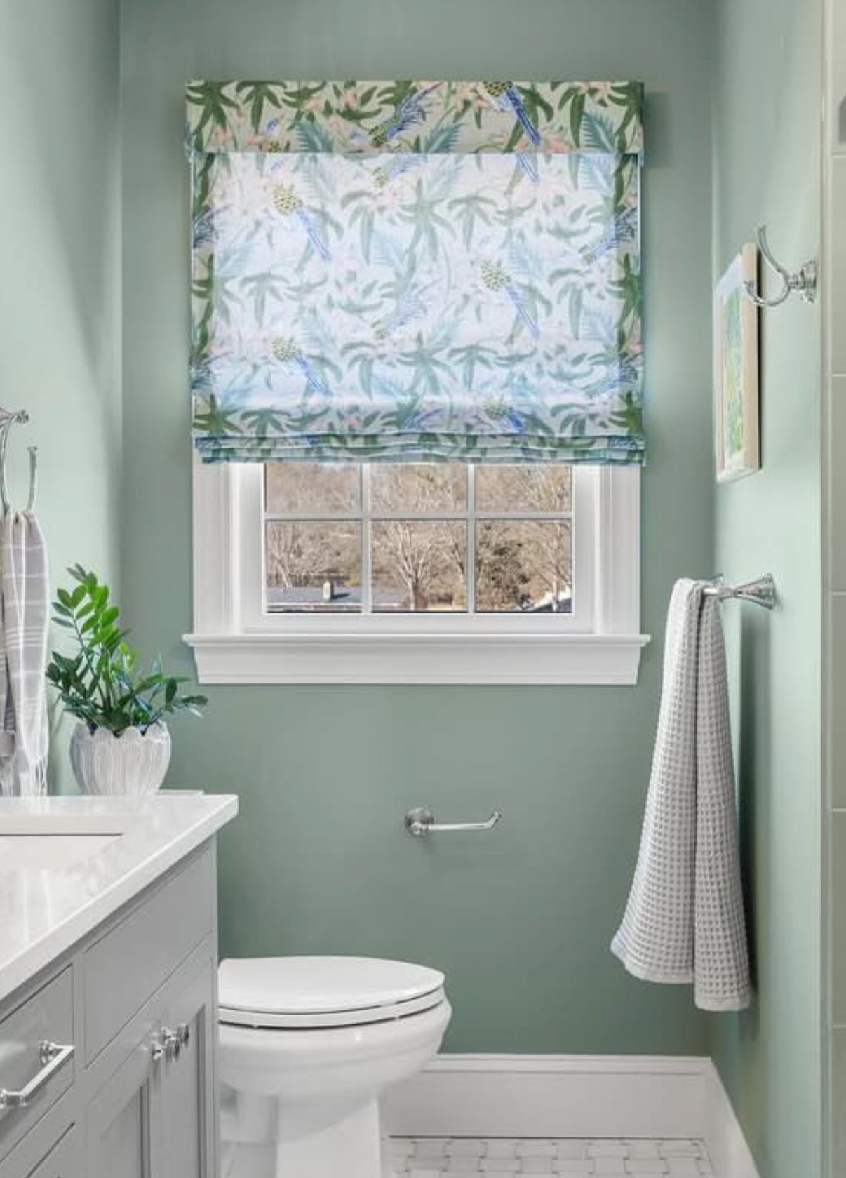 Sparrow Fabric - Caribbean Belgian Linen roman shade with blue parrots and palm leaves in a bathroom.
