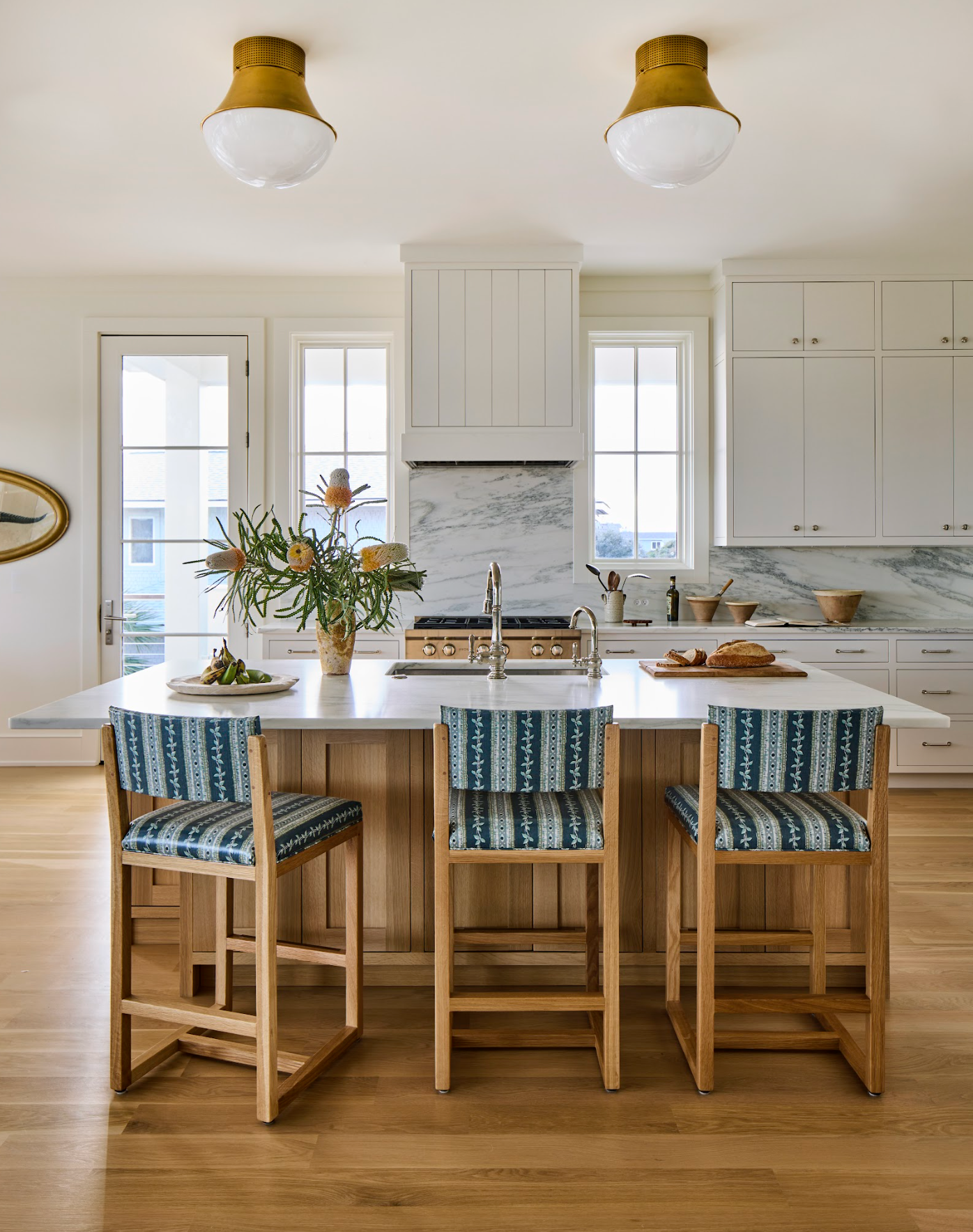 Kitchen island with three wooden bar stools upholstered in blue and white Trellis Fabric - Marine.
